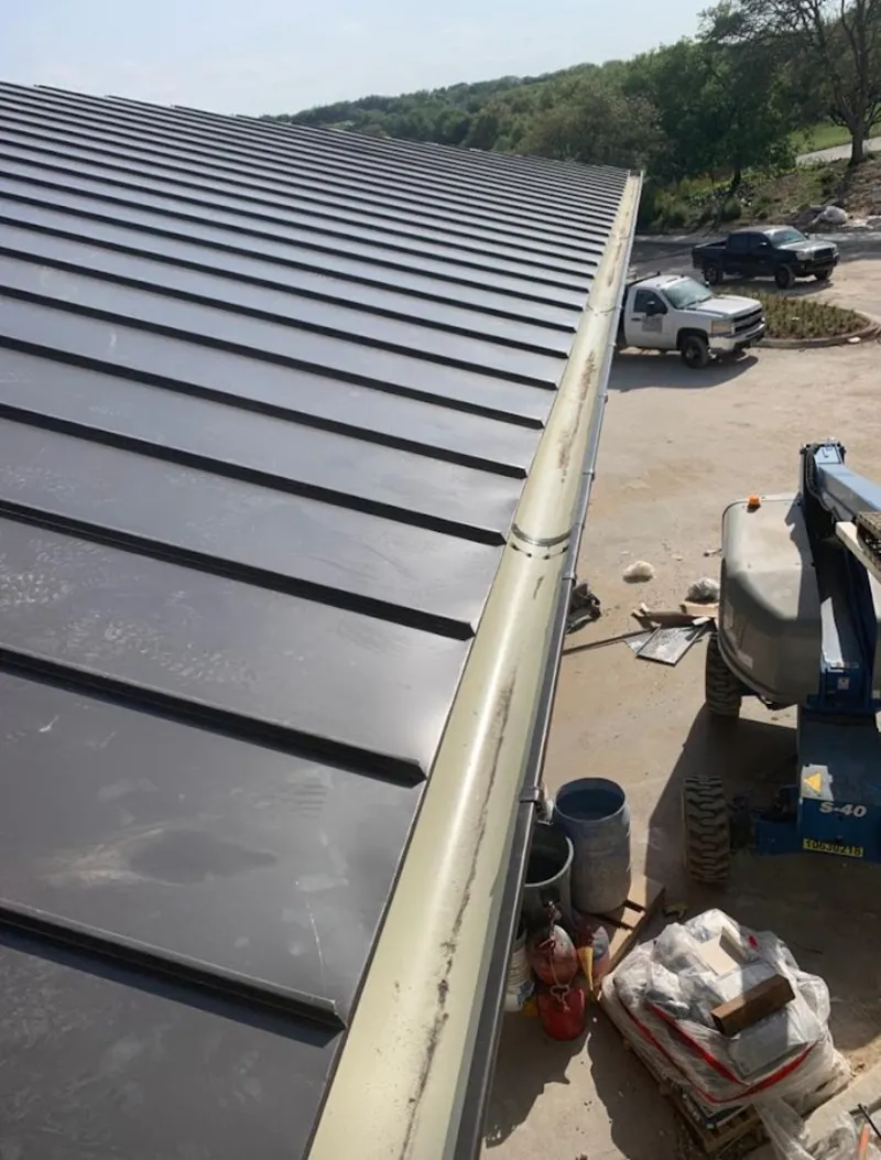 Standing seam panel and gutter detail on a metal roofing jobsite in Russellville